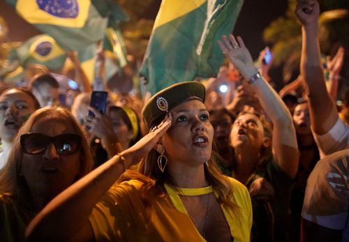 A supporter of Jair Bolsonaro celebrates his victory with a military style salute in Rio de Janeiro.