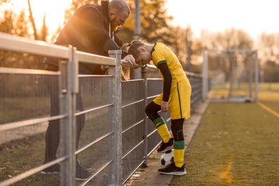 Father speaking to his daughter during a soccer match