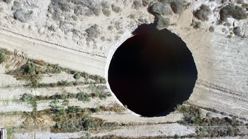The sinkhole opened up in Chile on land owned by a Canadian mining company. 