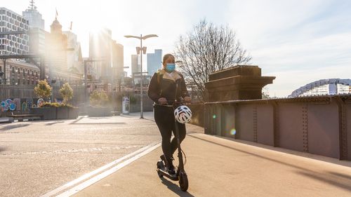 A woman riding a scooter wearing a face mask at Flinders Street station amid Melbournes lockdown.