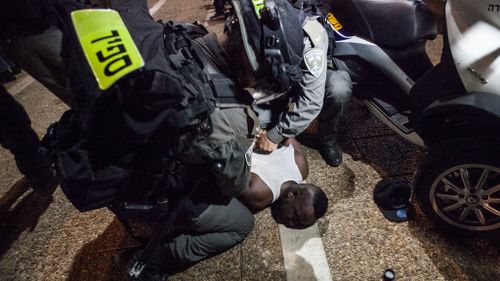 An Ethiopian Jew is cuffed on the ground by Israeli police. (AFP)