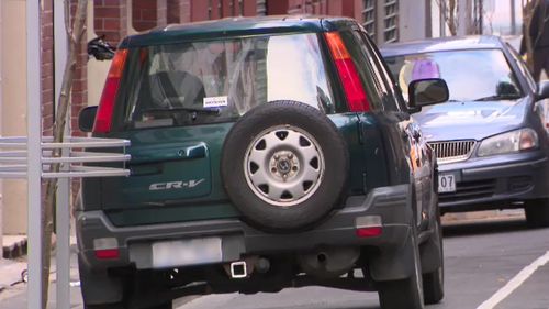 Forensic investigators have spent the morning focusing on a green Honda parked on a street near the building.  Picture: 9NEWS