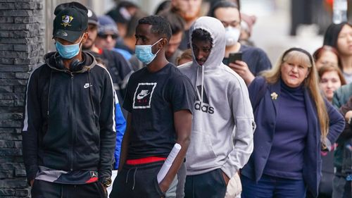 People are seen in long queue outside a Centrelink office in Abbotsford, Melbourne, Monday, 