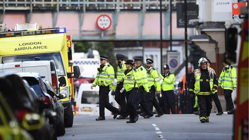 Police and fire services gather at the scene of an incident on the District line in London. (AAP)