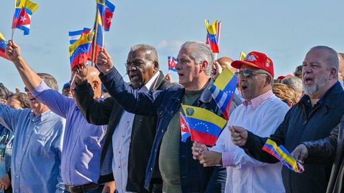 Cuba's President Miguel Diaz-Canel flutters a Venezuelan national flag in support of Venezuelan leader Nicolas Maduro in Havana on January 3 after US forces captured him.