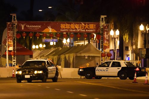 Deux véhicules de police sont vus près d'un bâtiment où une fusillade a eu lieu dans le parc de Monterey.