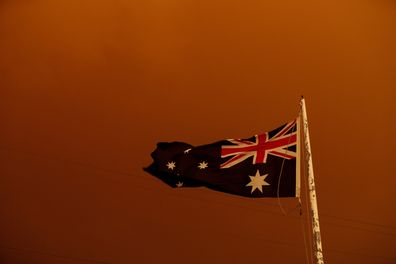 The Australia Flag flies under red skies from the fires on January 04, 2020 in Bruthen Australia, in East Gippsland. (Photo by Darrian Traynor/Getty Images)