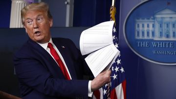 President Donald Trump holds up papers as he speaks about the coronavirus in the James Brady Press Briefing Room of the White House on April 20, 2020, in Washington.   