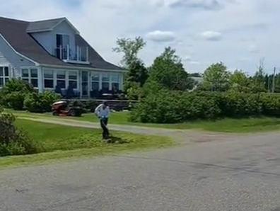 Neighbour mows lawn during wedding video