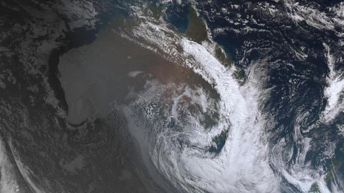 The thick cloud coverage is visible from space, with a clear crescent storm system floating above the East Coast.