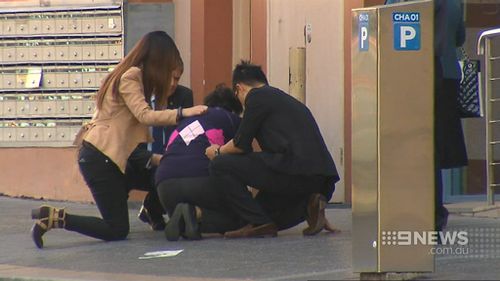 Selina Cheng collapsed on the ground after visiting the scene of her husband's murder. (9NEWS)