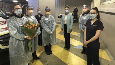 A team of nurses gather in the ambulance bay to surprise one of their colleagues.