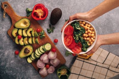 veggie bowl held by female hands, overhead view. High quality photo