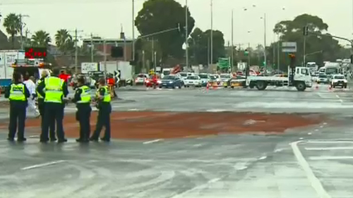 Crews are cleaning up a fuel spill over the road. (9NEWS)