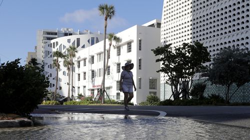 A woman walks along a flooded street caused by a king tide in Miami Beach last year.