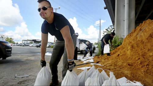 Kevin Orth loads sandbags into cars on Milford Street as he helps residents prepare.