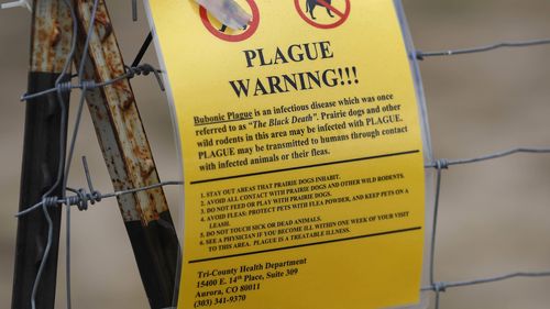 A sign warning of bubonic plague is displayed at a parking lot near the Rocky Mountain Arsenal Wildlife Refuge in Commerce City, Colorado, USA.