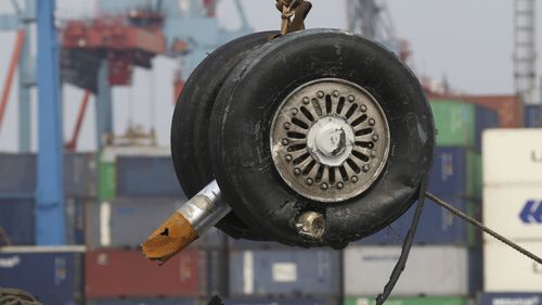 A crane moves a pair of wheels recovered from the Lion Air jet that crashed into the Java Sea.