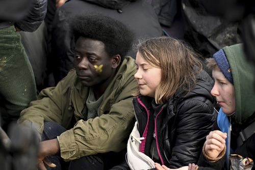 Police officers have encircled a group of activists and coal opponents with climate activist Greta Thunberg, centre, on the edge of the Garzweiler II opencast lignite mine during a protest action by climate activists after the clearance of Luetzerath, Germany, Tuesday, Jan. 17, 2023. 