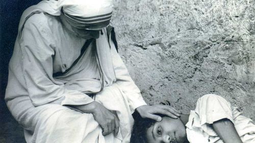 Mother Teresa comforts a sick child. (AAP)