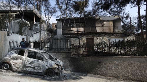 A Mati local outside the remnants of his burned home. Picture: AP