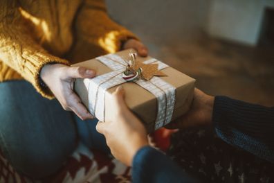 Close-up photography of two hands while giving christmas gift.