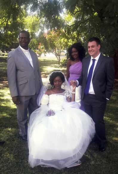 In this photo taken on Saturday, May, 5, 2018, Zenele Ndlovu, center, and Jamie Fox hold hands on their wedding day at a hospital Chapel in Bulawayo, Zimbabwe. A couple attacked by a crocodile wedded days later in a Zimbabwean hospital, where the bride was recovering after losing an arm. "In one week we went from shock and agony to a truly amazing experience," Fox told The Associated Press on Monday, May 7. (AP Photo)