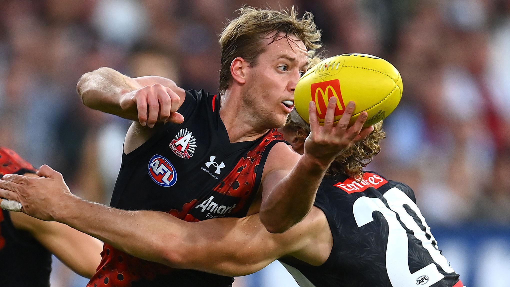 MELBOURNE, AUSTRALIA - APRIL 25: Darcy Parish of the Bombers handballs whilst being tackled by Will Kelly of the Magpies during the round six AFL match between Collingwood Magpies and Essendon Bombers at Melbourne Cricket Ground, on April 25, 2023, in Melbourne, Australia. (Photo by Quinn Rooney/Getty Images)