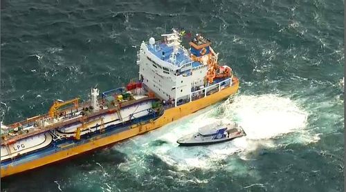 Queensland Water Police pulling alongside the Inge Kosan, following reports one crew member will be bought into hotel quarantine. 