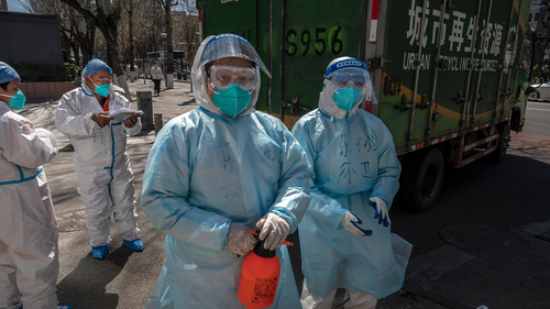 Health workers wear protective suits as they disinfect after loading medical waste on a truck to be removed from a community that was recently opened after it was locked down for health monitoring when cases of COVID-19 were found in the area, on March 31, 2022 in Beijing, China. 