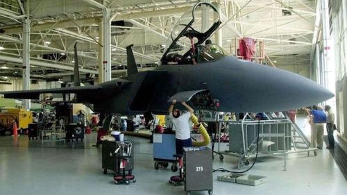 Workers at Boeing add the finishing touches to the final F-15E off the assembly line at the company's St. Louis facility on May 16, 2000.