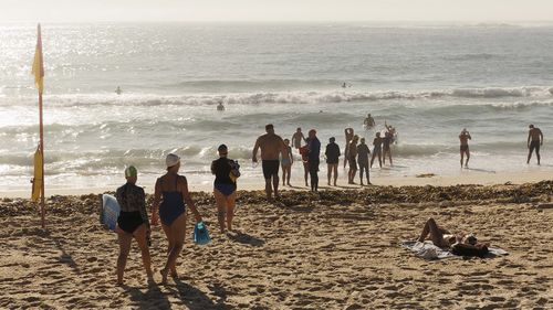 I nuotatori oceanici entrano in acqua a Coogee a Sydney mentre il sole splende sull'acqua.
