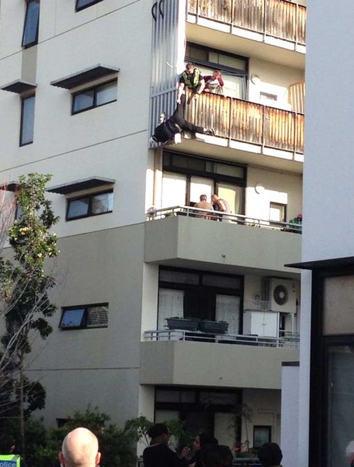 Tradie rescued after slip leaves him dangling from third-floor balcony by his foot