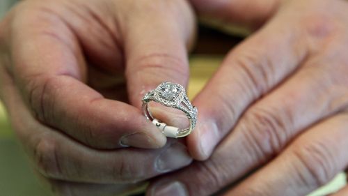 FILE - A jewelers displays an engagement ring on May 14, 2014, in Jacksonville, N.C. (Maria Sestito/The Daily News via AP, File)