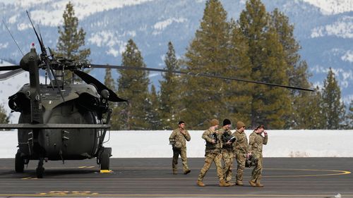 U.S. Army soldiers exit a Black Hawk at the Truckee Tahoe Airport in Truckee, Calif., Saturday, Feb. 21, 2026, after aiding in recovery efforts for a group of skiers who went missing during a deadly avalanche.