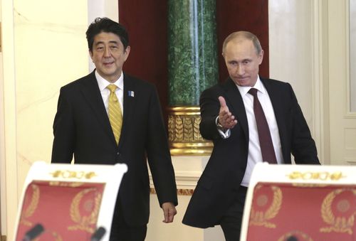 Le président russe Vladimir Poutine, à droite, et le Premier ministre japonais en visite Shinzo Abe marchent dans une salle pour participer à une conférence de presse finale au Kremlin de Moscou, le lundi 29 avril 2013. 