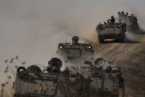 Israeli APCs head towards the Gaza Strip border in southern Israel on Friday, Oct.13, 2023.