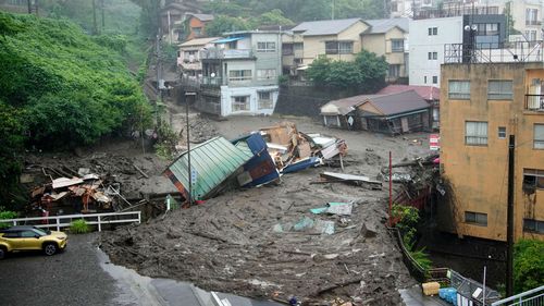 Houses are damaged by mudslide following heavy rain at Izusan district in Atami, west of Tokyo, Saturday, July 3, 2021. 