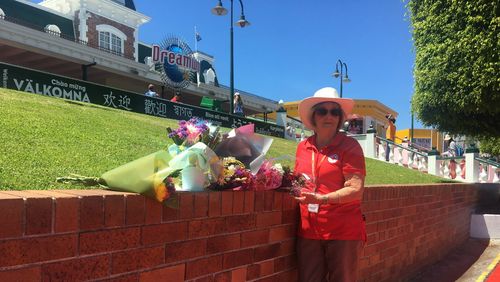 Red Cross volunteer Pamela Howarth with floral tributes laid outside Dreamworld one year on.