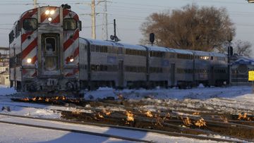 A Metra train moves southbound to downtown Chicago as the gas-fired switch heater on the rails keeps the ice and snow off the switches near Metra Western Avenue station in Chicago.