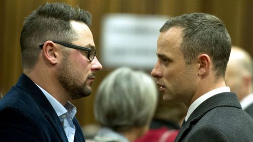 Oscar Pistorius talks to his brother, Carl Pistorius at the Pretoria High Court on May 20. (Getty Images)