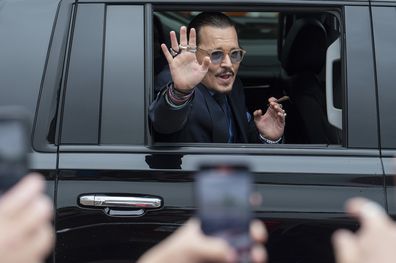 Johnny Depp waves to supporters as he departs the Fairfax County Courthouse