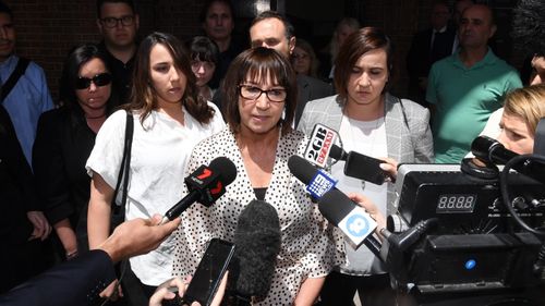 Jennifer Karmas (centre), the wife of murder victim Elisha "Sam" Karmas, speaks to the media, surrounded by family, outside the NSW Supreme Court in Sydney, Thursday, November 8, 2018. 
