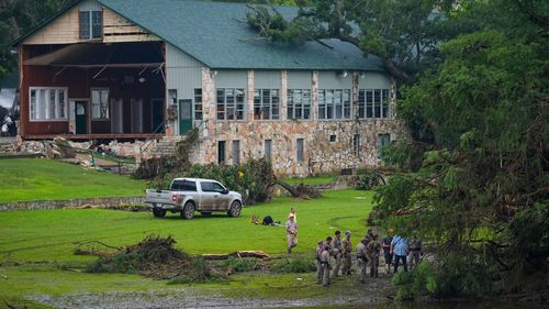 Officials search on the grounds of Camp Mystic on Sunday in Hunt, Texas.