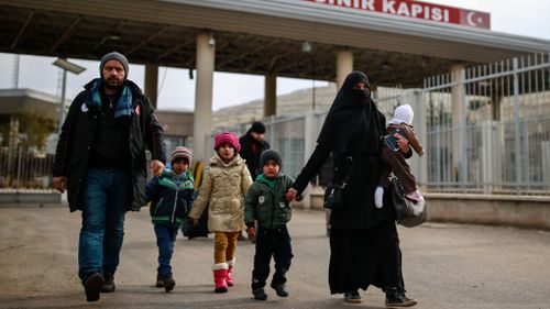 A Syrian family walks after crossing into Turkey at the Cilvegozu border gate yesterday. (AAP)