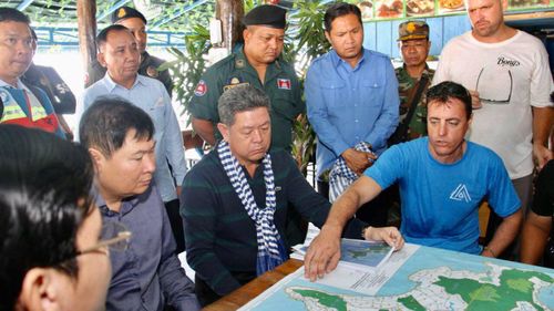 Sihanoukville provincial Governor Kuoch Chamroeun, center, looks at a map of Koh Rong where British national Amelia Bambridge went missing.