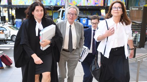 Australian actor Geoffrey Rush (centre) arrives at the Federal Court in Sydney, Wednesday, October, 31, 2018.