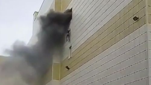 Sergey Moskalenko climbs out of the opening window to escape the billowing smoke and flames.