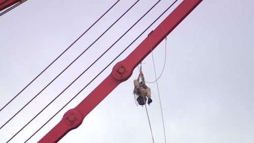 Protester suspends themselves from crane at Port Botany.