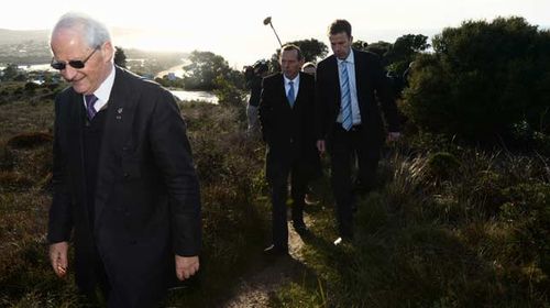 Philip Ruddock leads Tony Abbott and MP Dan Tehan through the scrub on the Great Ocean Road near Anglesea, Victoria, during the 2013 election campaign. (AAP)